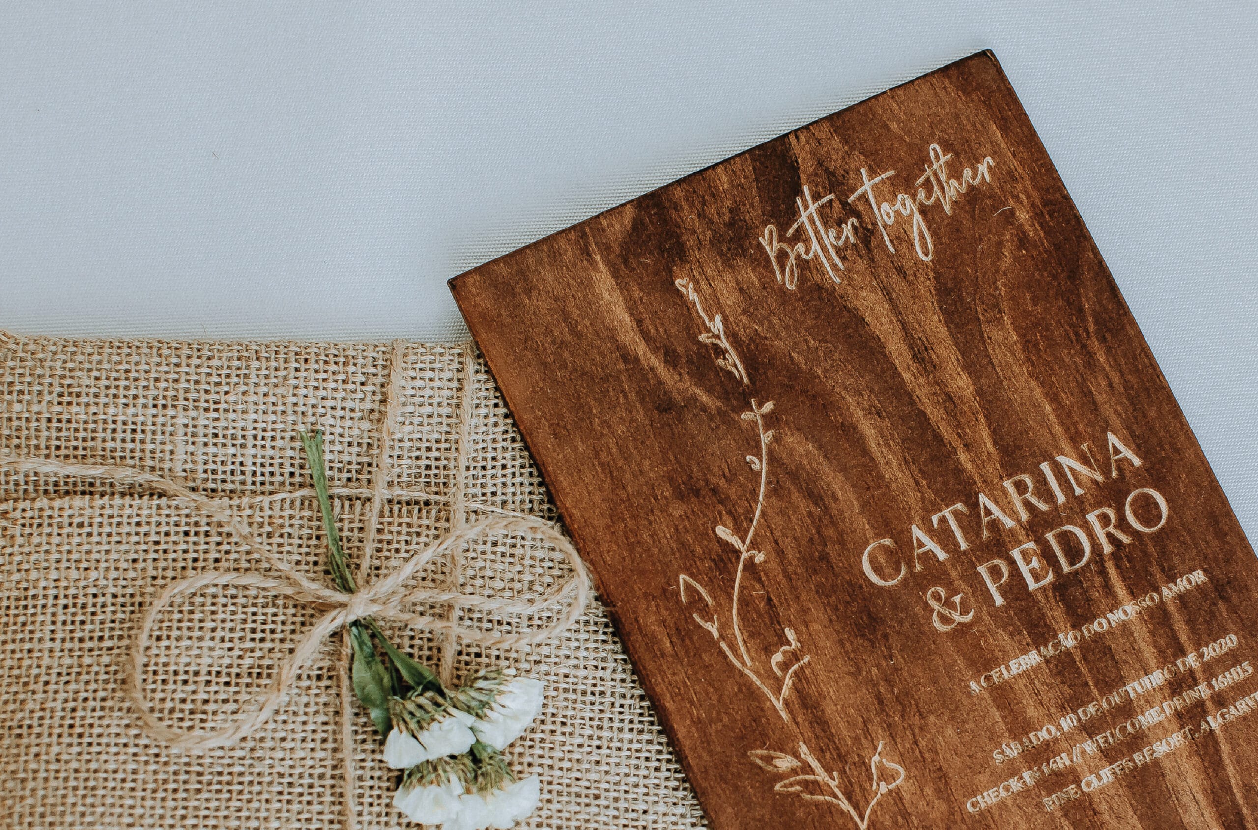 Convite de casamento da atriz Catarina Gouveia de madeira com envelope feito de manto de serapilheira bege com um cordão e flores