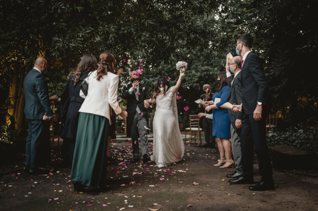 Familiares a atirar petalas de rosas cor de rosa aos noivos