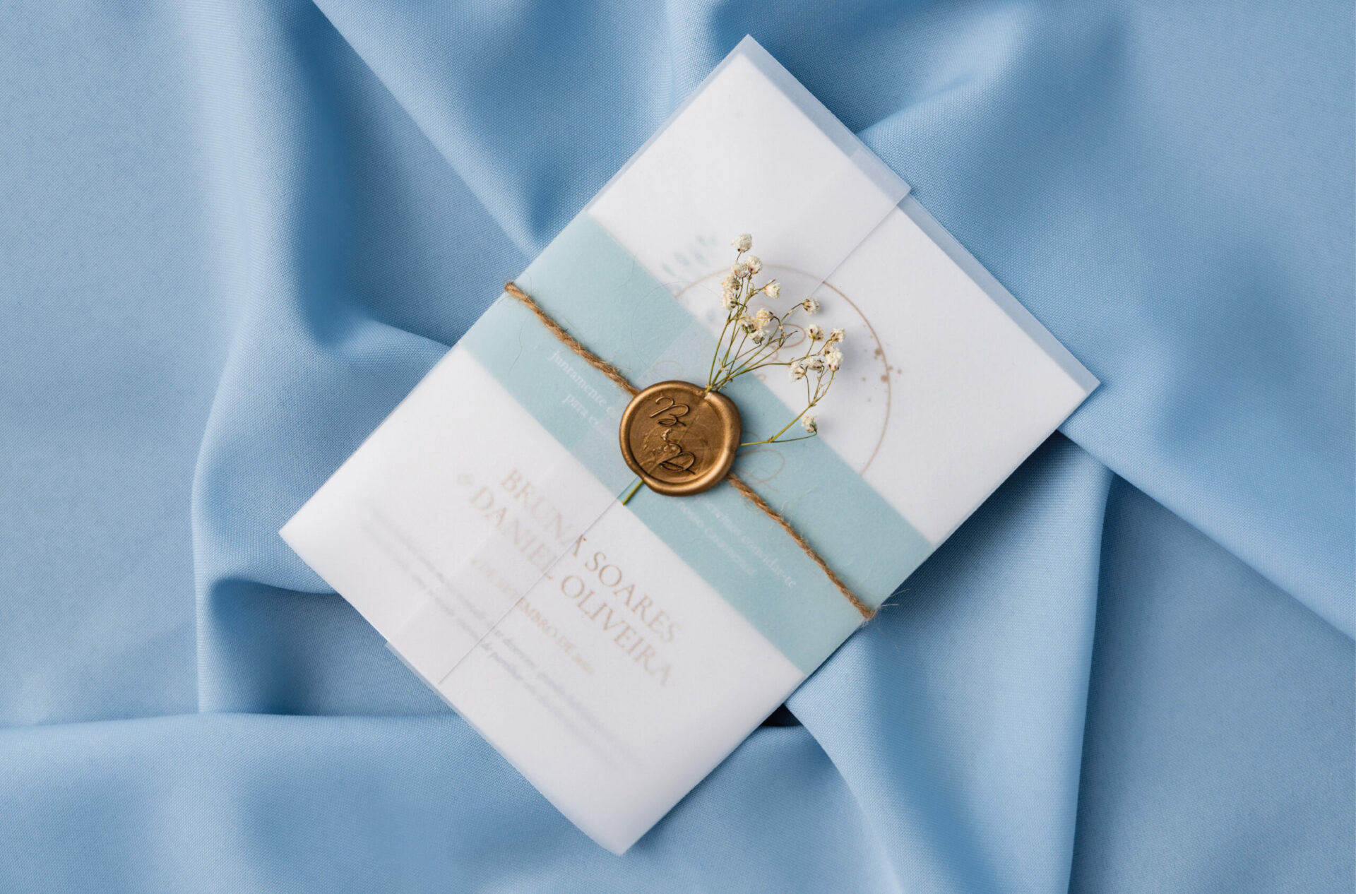 Convite de Casamento branco de estilo Aguarela com tipografia dourada e ilustração em aguarela com um envelope em papel vegetal com lacre dourado em fundo azul