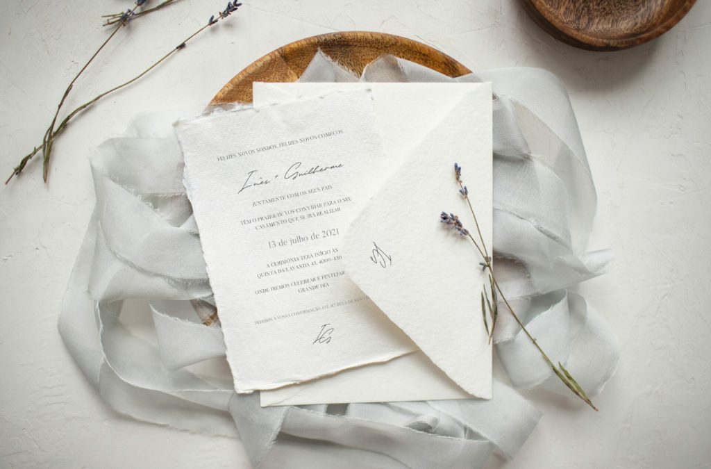 Convite de Casamento branco de estilo tipográfico com acabamento rasgado com flores de lavanda e envelope branco.