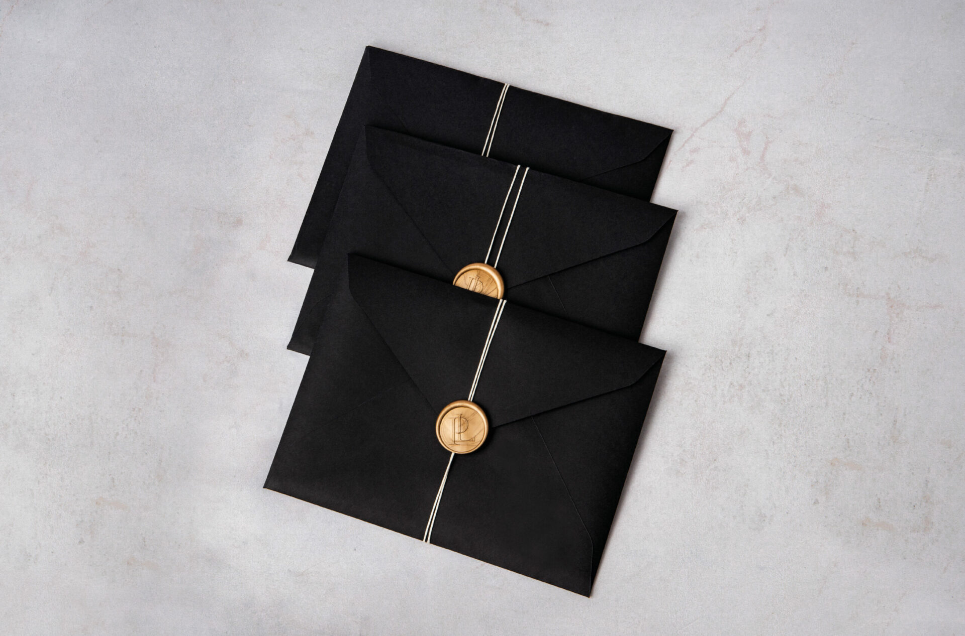Envelope de preto com fio branco e lacre dourado