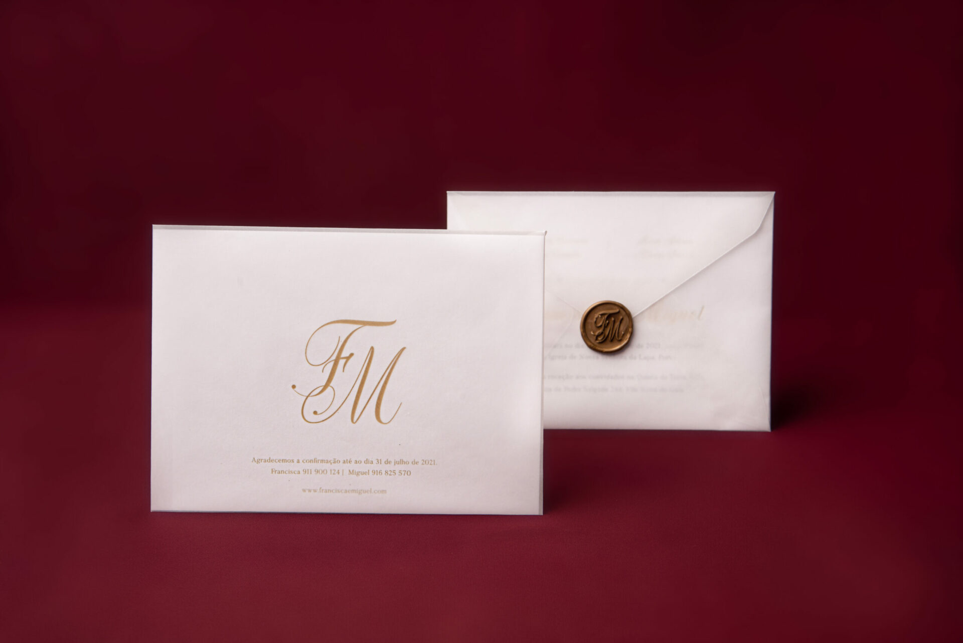 Convite de casamento branco de estilo tipográfico com foil dourado num fundo bordô